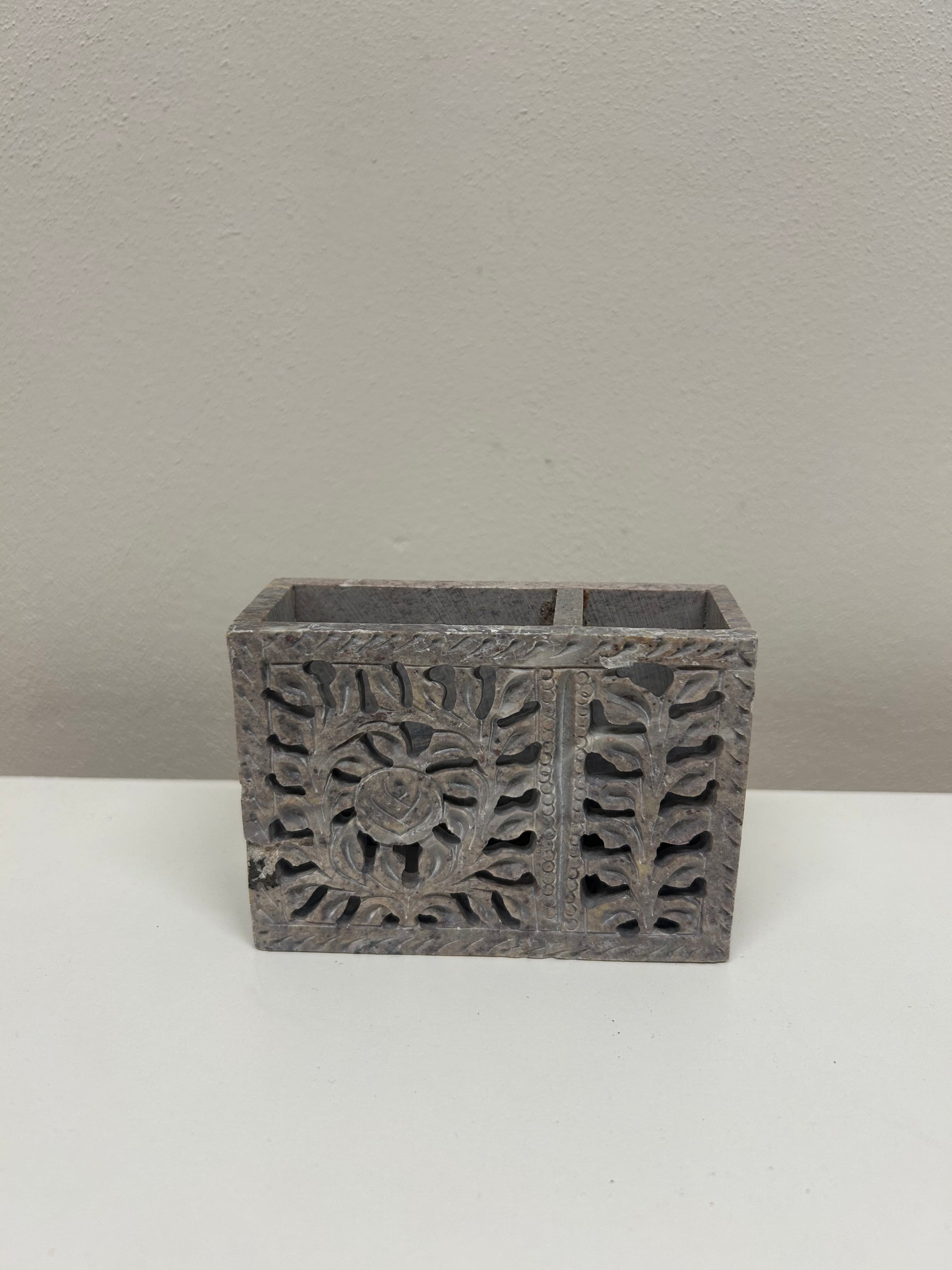 Kamenný stojan s vyřezávaným dekorem