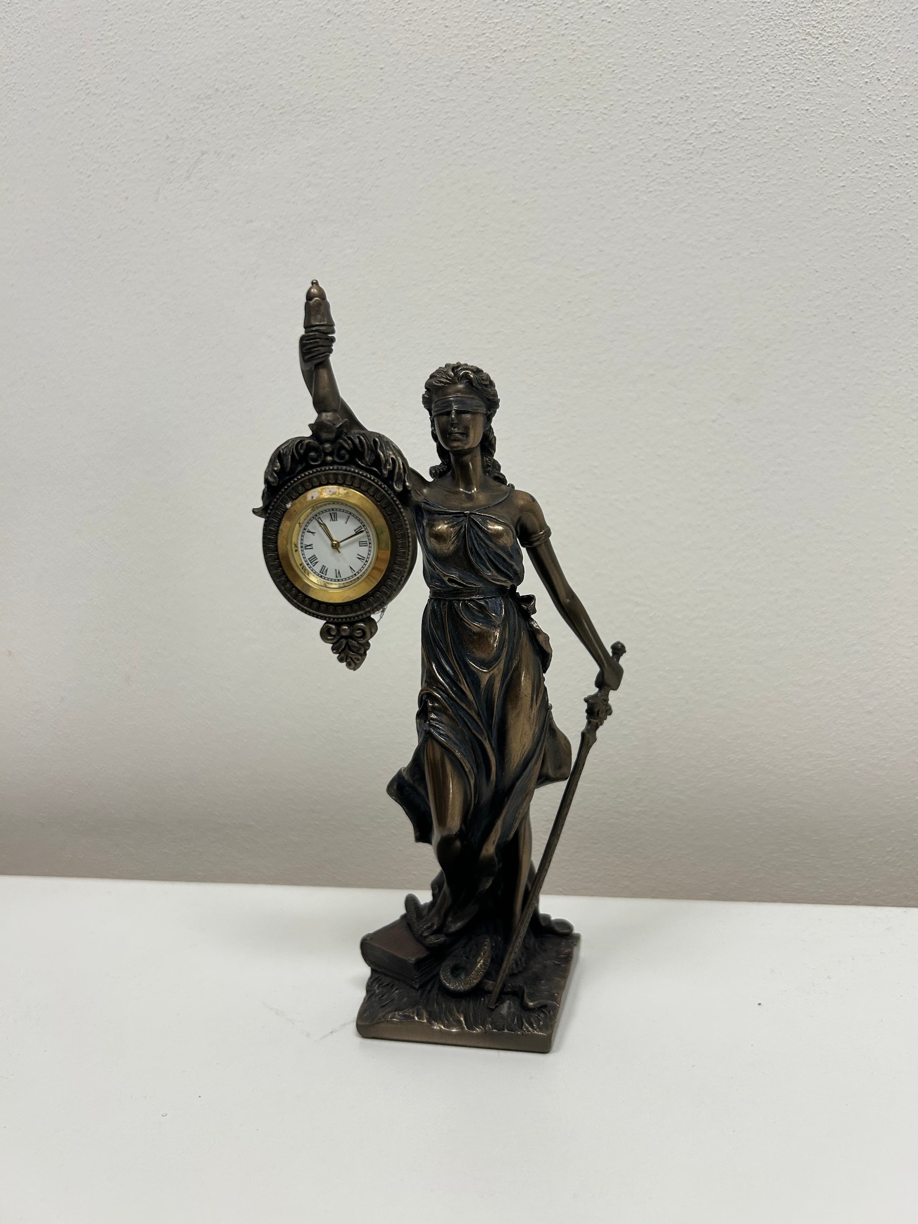 Justitia — bronzová socha bohyně spravedlnosti s hodinami